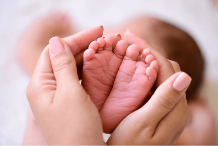 Babies feet cradled in parents hands.png